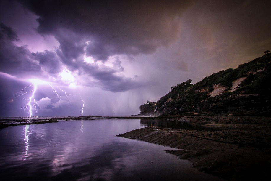 Lightening strikes over an ocean.